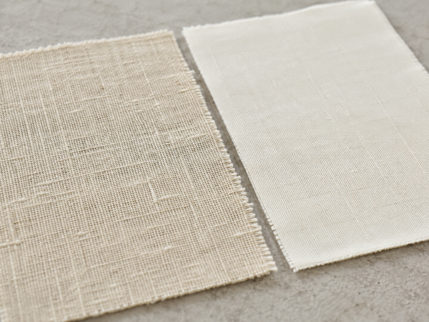 Close-up comparison of natural linen fabric and cotton fabric showing linen’s crisp texture beside cotton’s smoother weave.