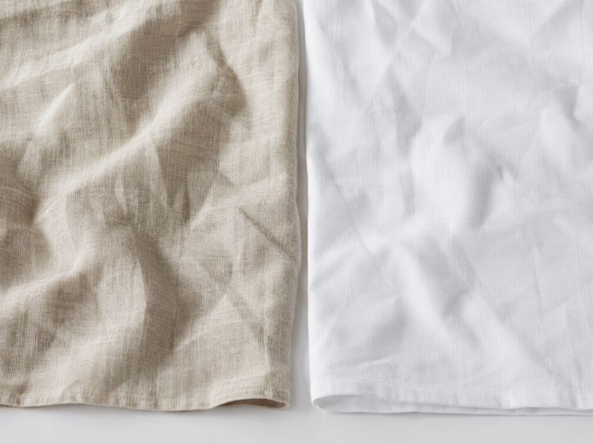 Wrinkled linen fabric beside lightly creased cotton fabric showing the difference in wrinkle behavior between linen and cotton.