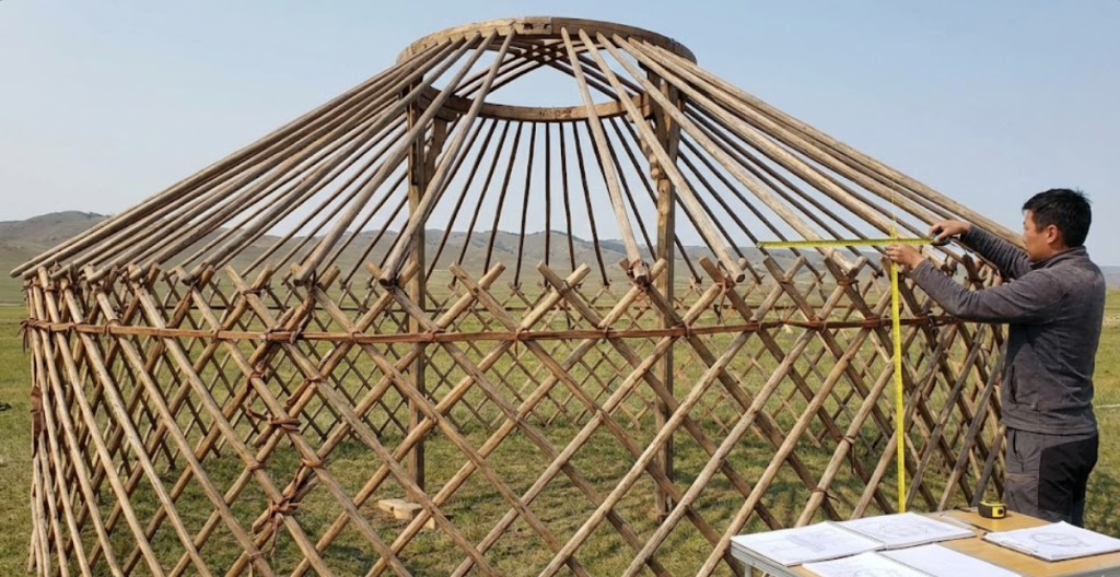 Traditional yurt wooden frame displaying the khana lattice walls, uni roof poles, and toono crown ring for custom canvas measurements.