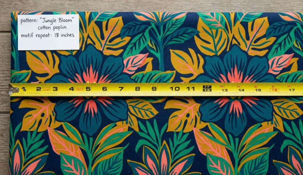 Printed apparel fabric laid flat with a measuring tape placed across the floral pattern to indicate exact scale and motif repeat size.